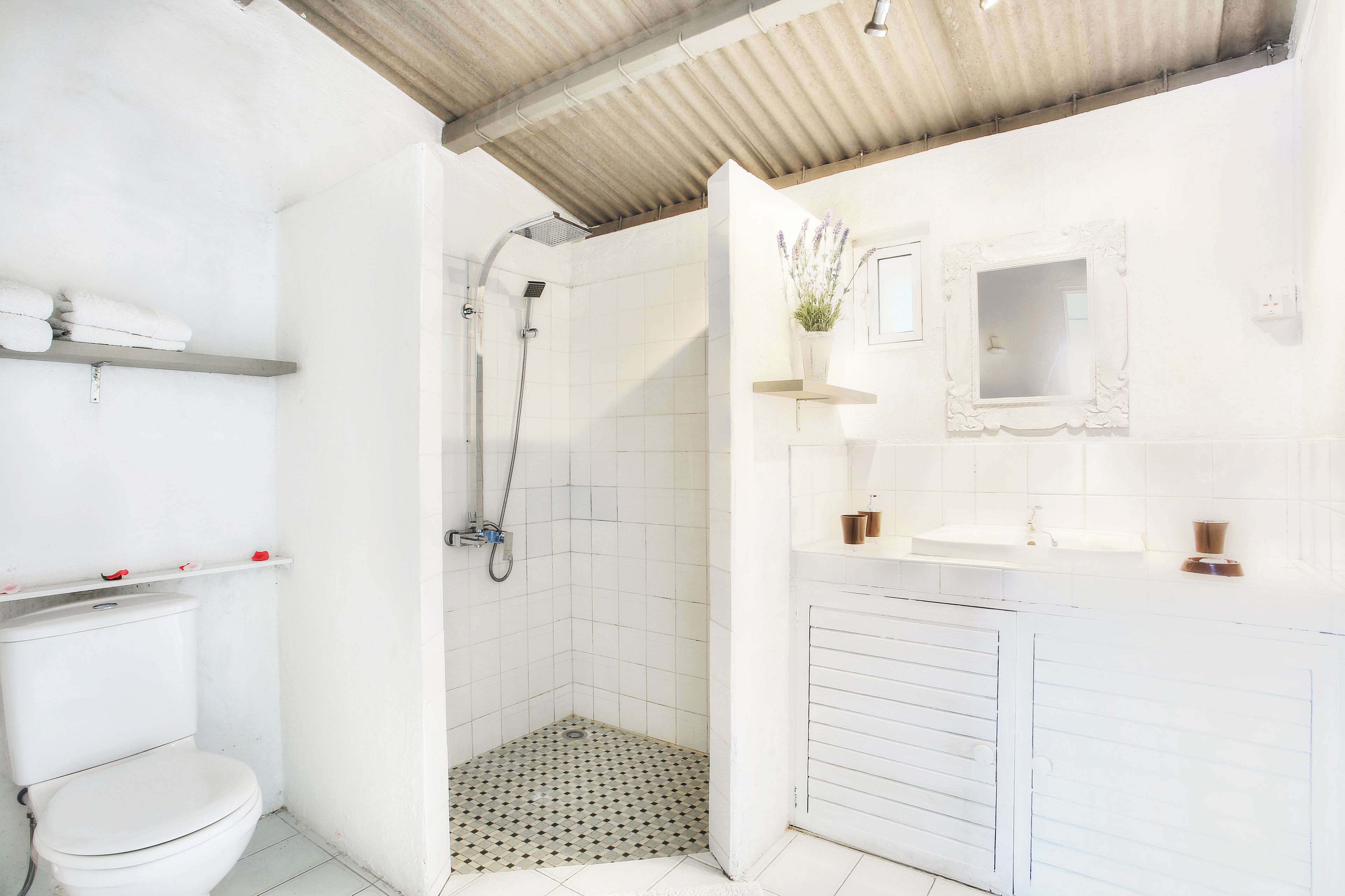 A bathroom with a toilet, shower, and sink.