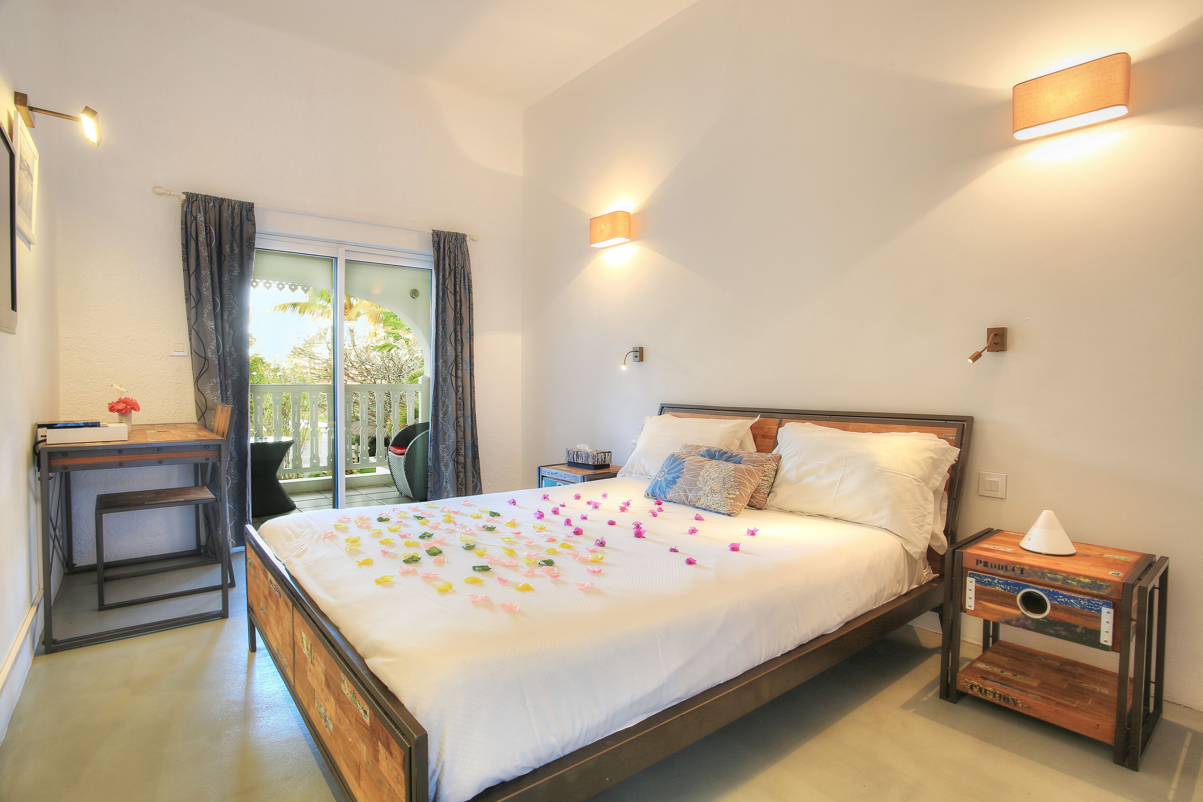 A bedroom with a bed, bedside tables, a desk, and a window with curtains.