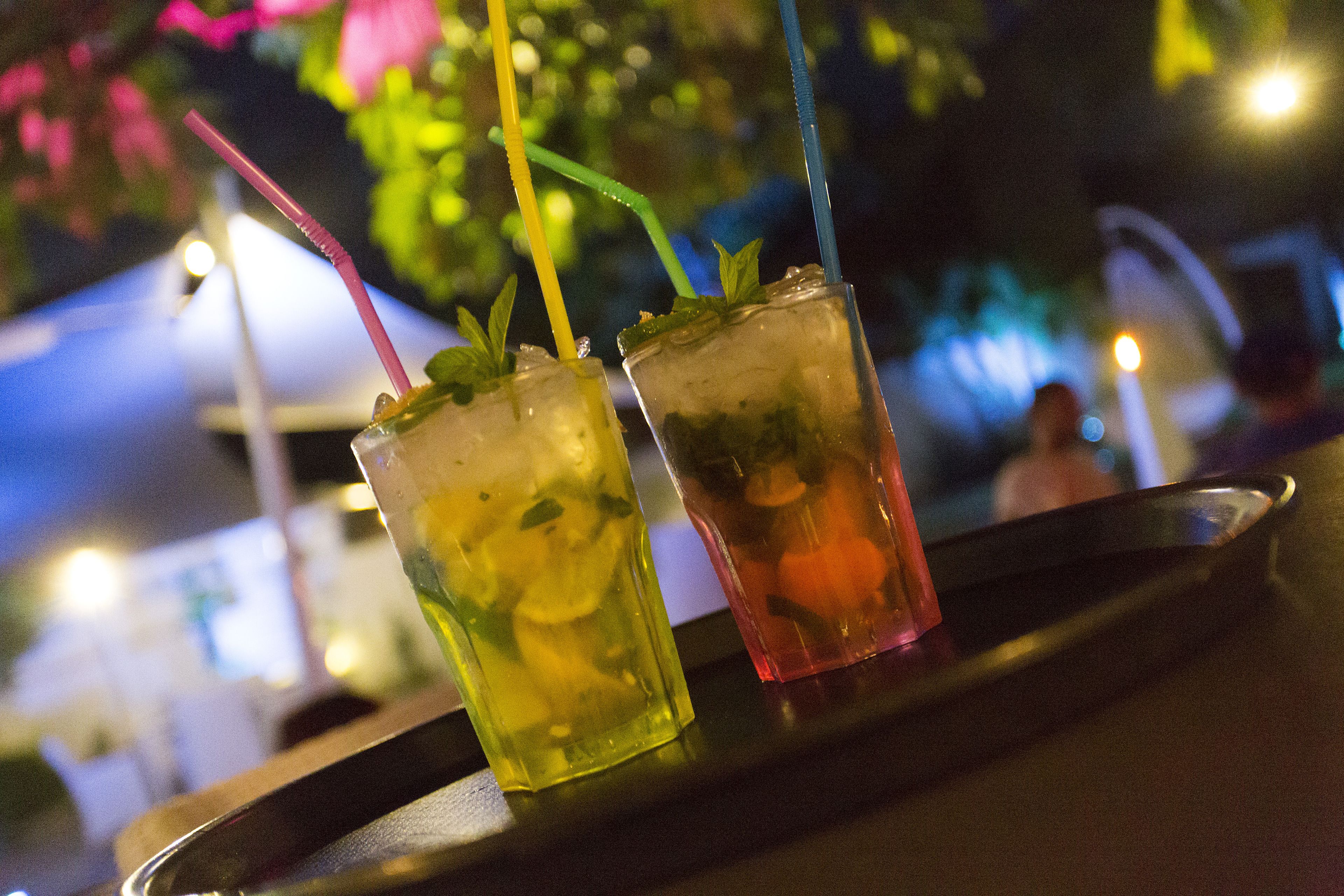 Two drinks with straws on a tray.