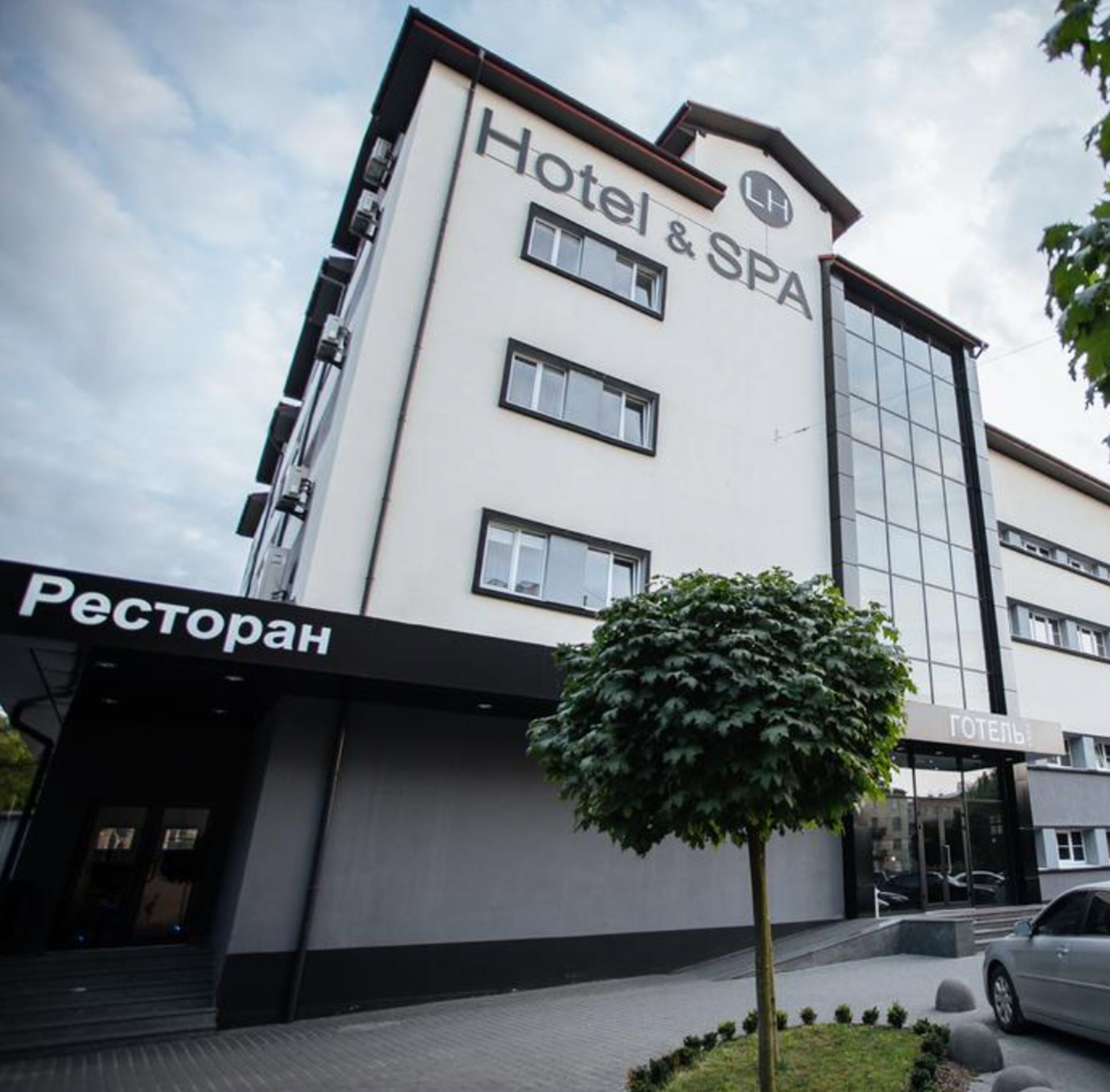 A hotel named "Hotel & SPA" with a modern facade, large windows, and a visible entrance.