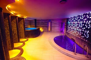 A spa area with a hot tub, tiled walls, and a pool. - LH Hotel & SPA (Lviv)