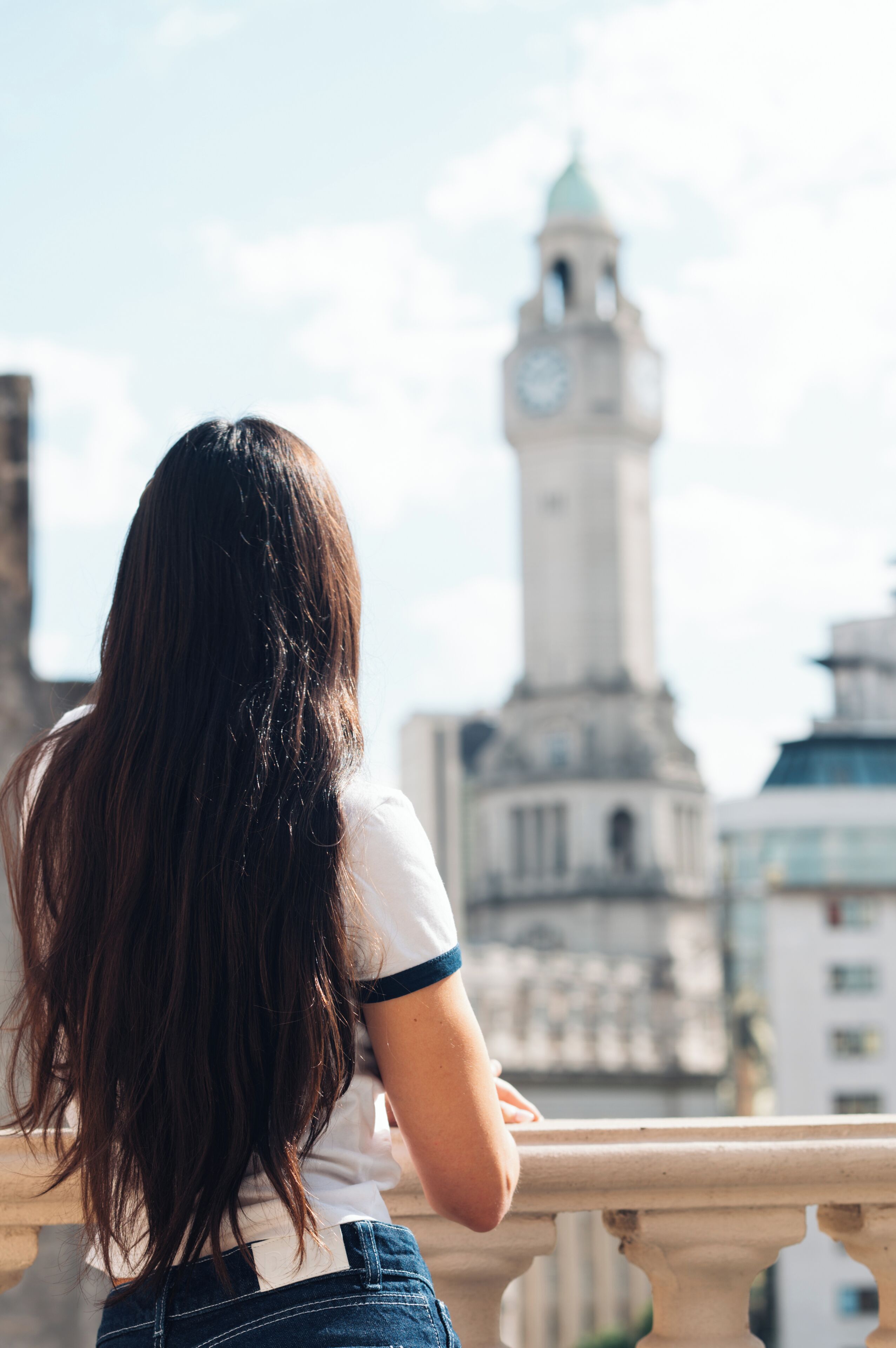 A person standing with a view of a clock tower in the background.