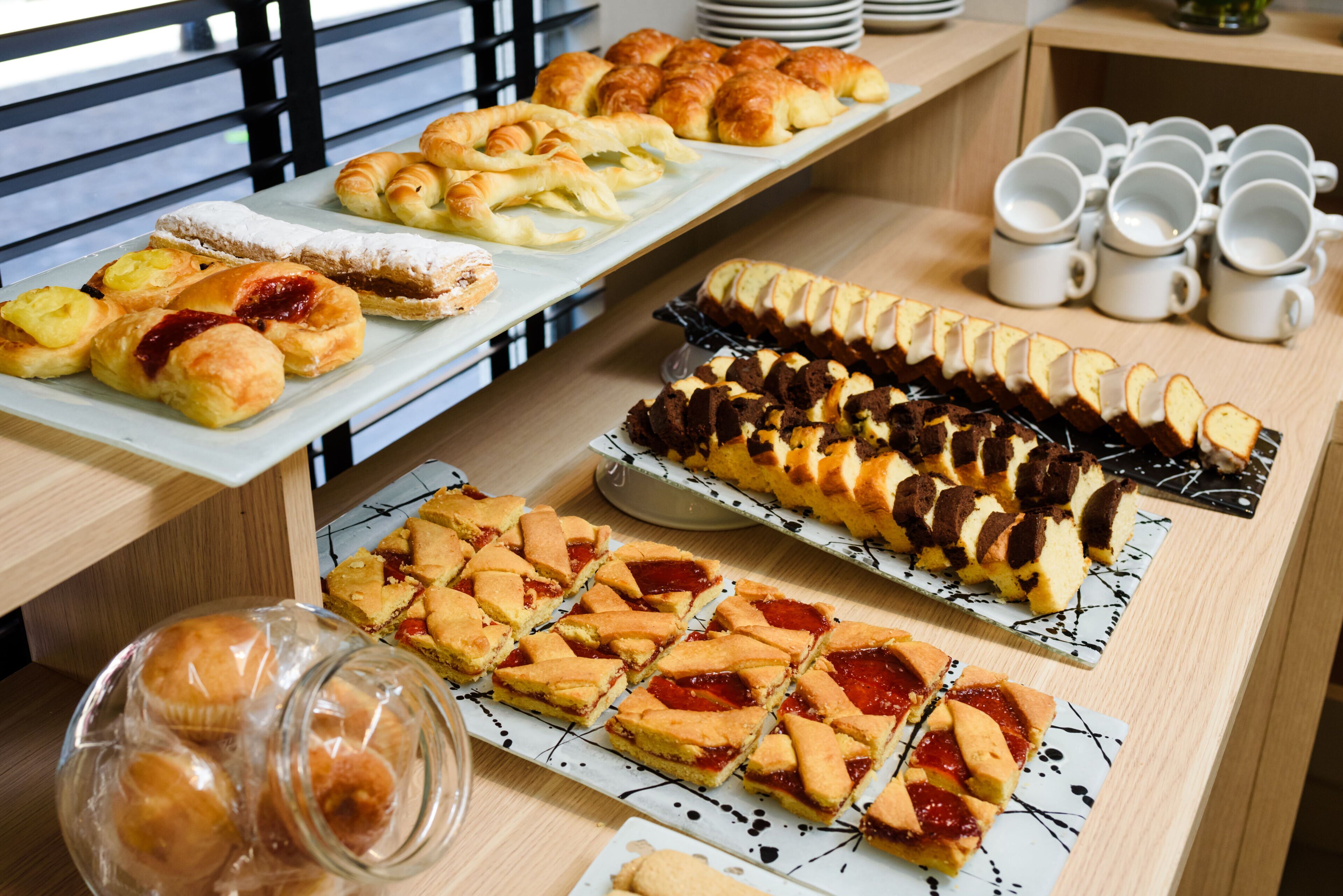 Noutopöydässä oli tarjolla monenlaisia leivonnaisia ja jälkiruokia, kuten croissantteja, piirakoita ja suuri kakku.
