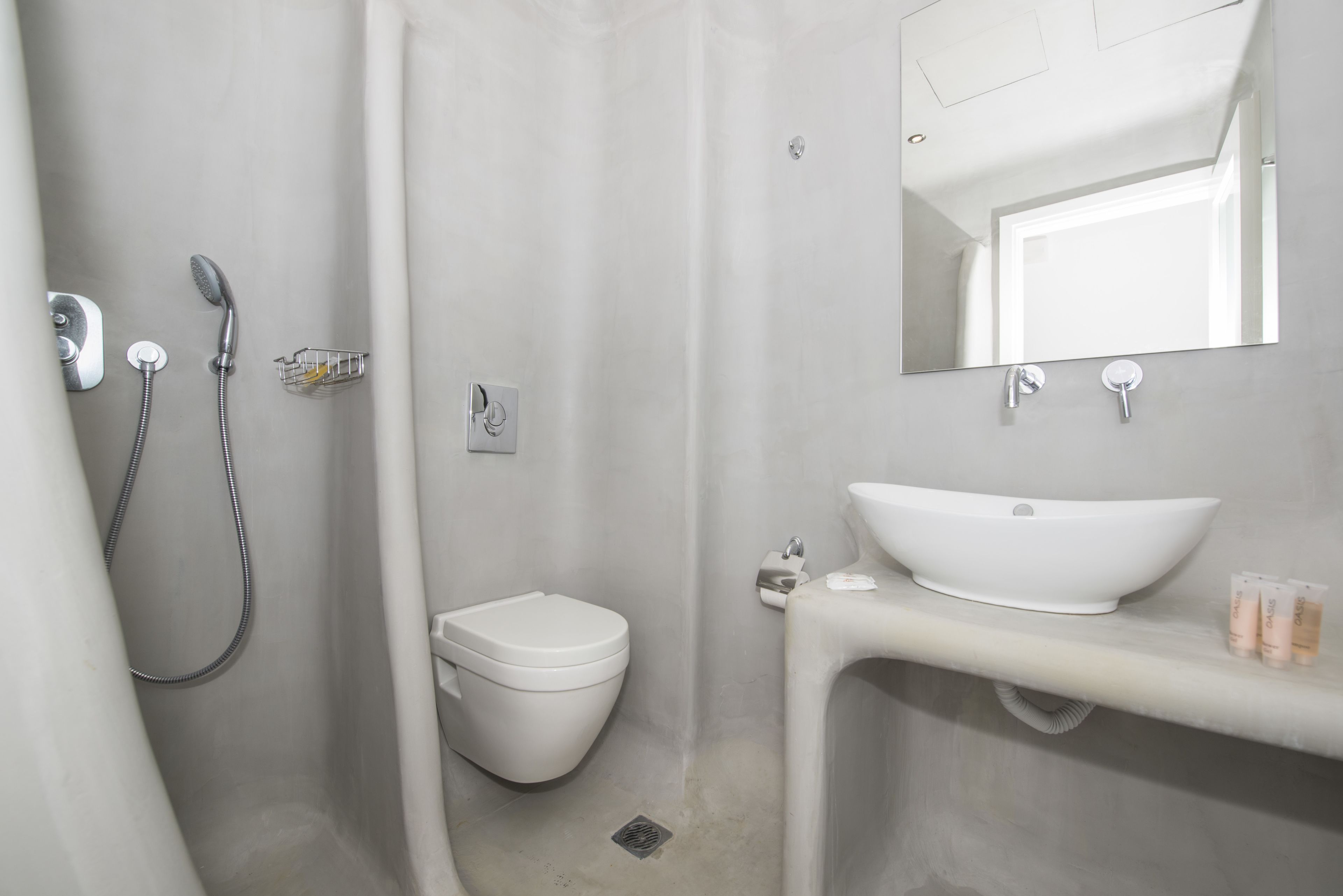 A modern bathroom with a white sink, mirror, and shower.