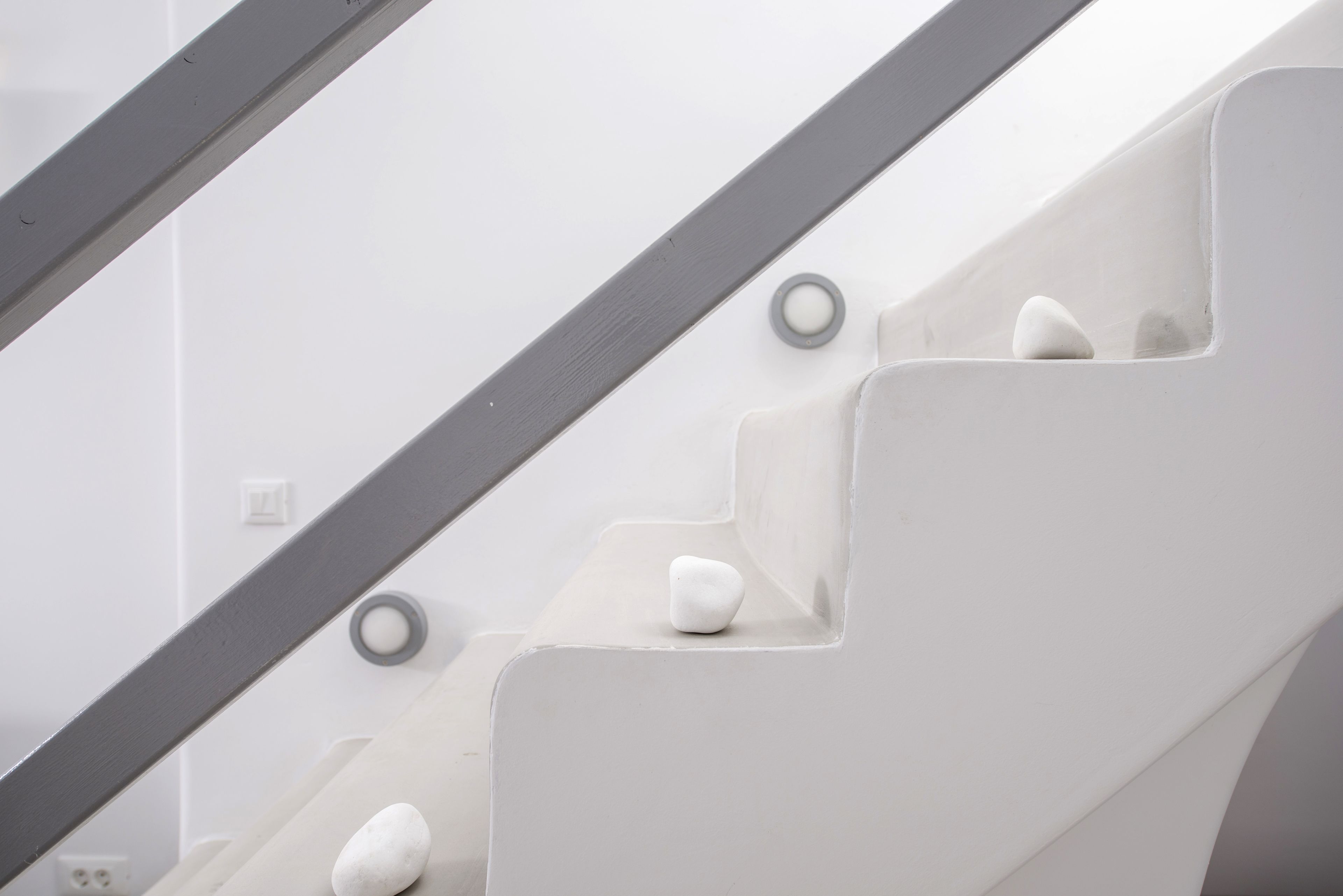 Una escalera blanca con barandilla de vidrio y diseño moderno.