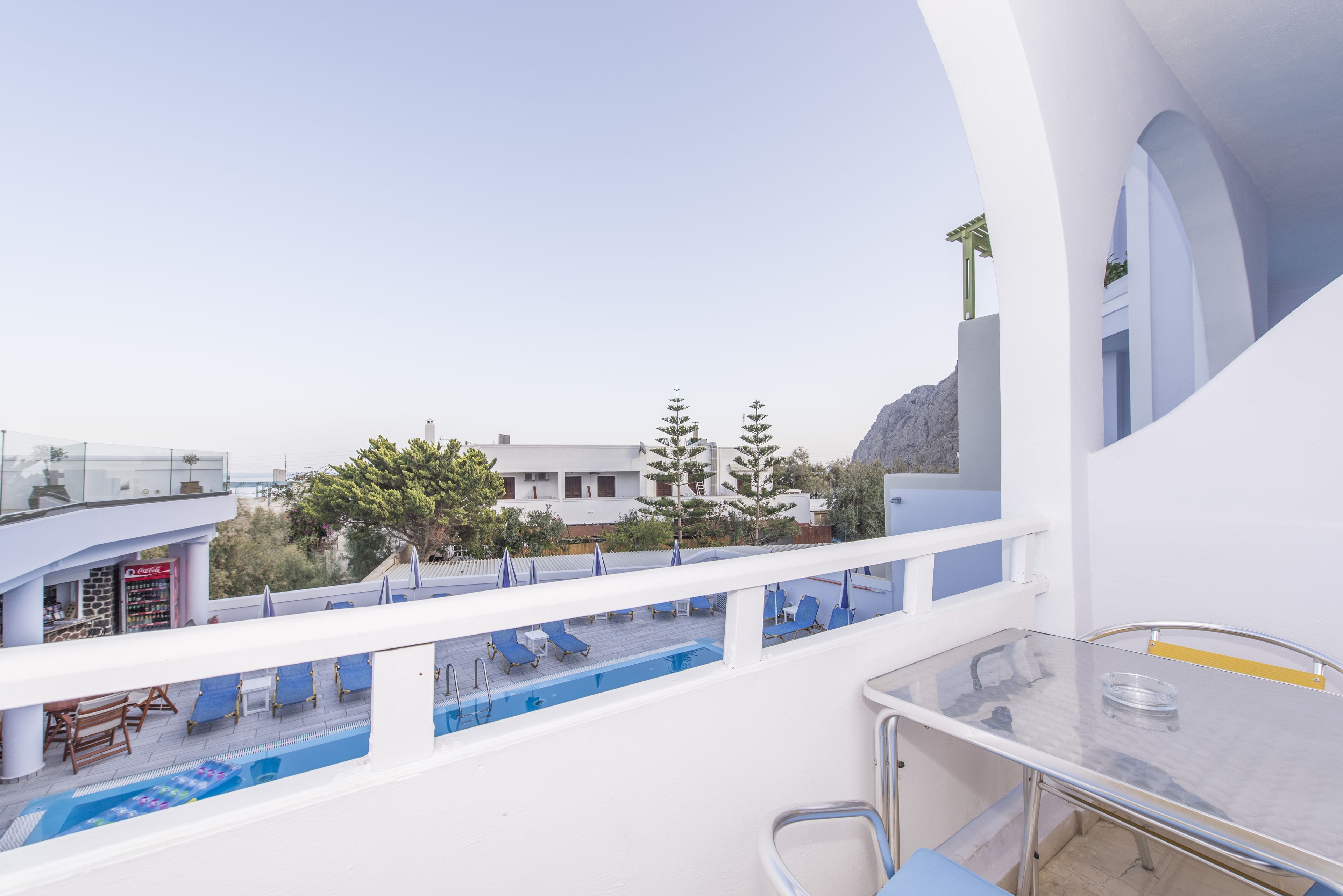 Ein Balkon mit Pool, Liegestühlen und einer Bar.