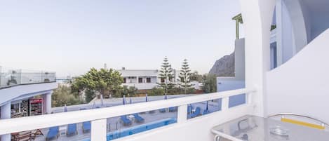 Uma varanda com piscina, espreguiçadeiras e um espaço bar.
