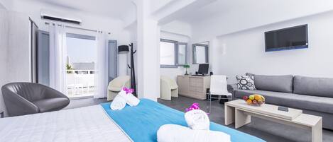 Une chambre d’hôtel moderne équipée d’un grand lit, d’un canapé, d’un bureau et d’une télévision.