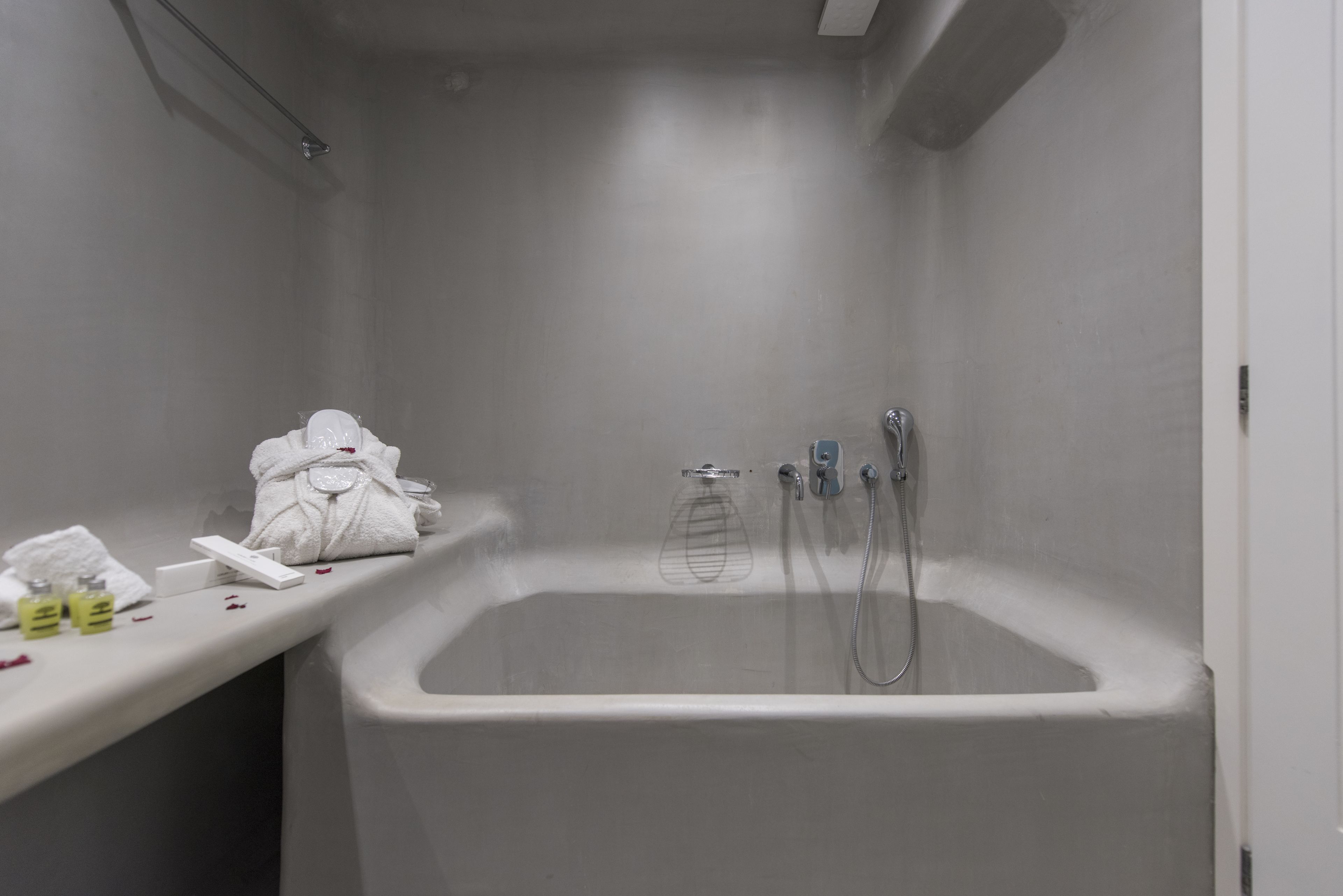 Un baño con bañera, una toalla y artículos de aseo.