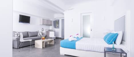 Una habitación de hotel moderna con cama, sofá, escritorio y televisión.