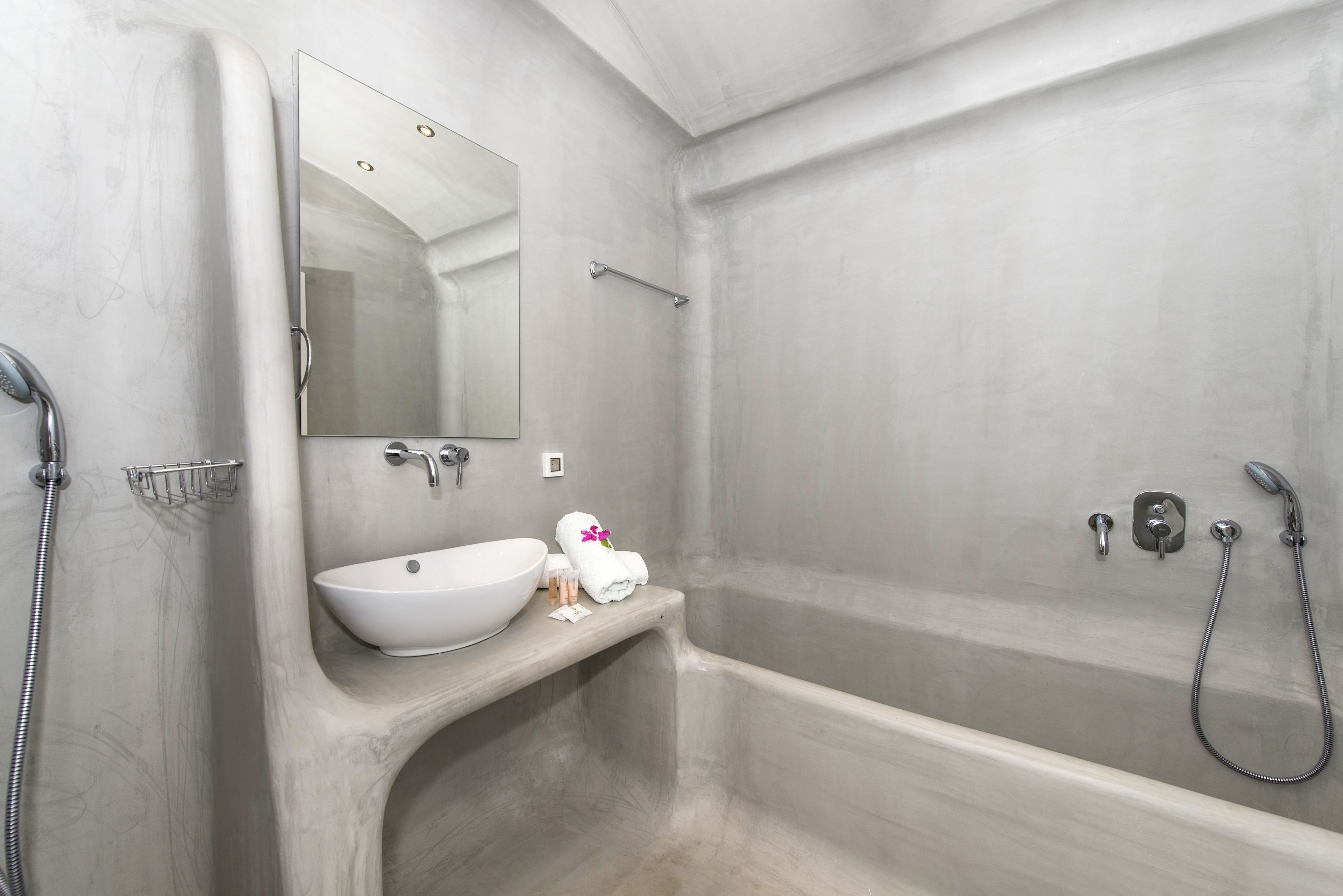 Une salle de bain moderne avec une baignoire sur pieds, un lavabo intégré et un grand miroir.