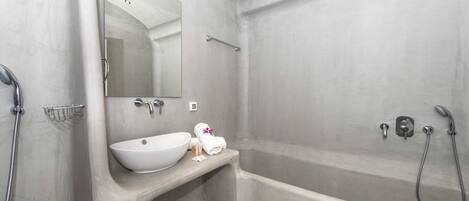 Une salle de bain moderne avec une baignoire sur pieds, un lavabo intégré et un grand miroir.