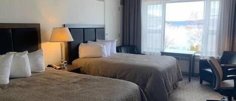 Una habitación de hotel con dos camas, un escritorio y una silla.
