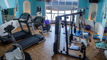 A gym with treadmills, weight machines, and exercise balls.