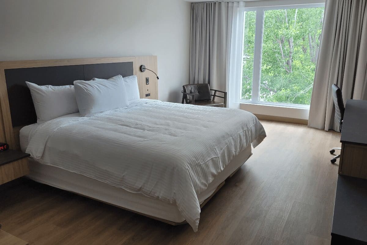 Een moderne hotelkamer met een groot bed, een bureau en een stoel.