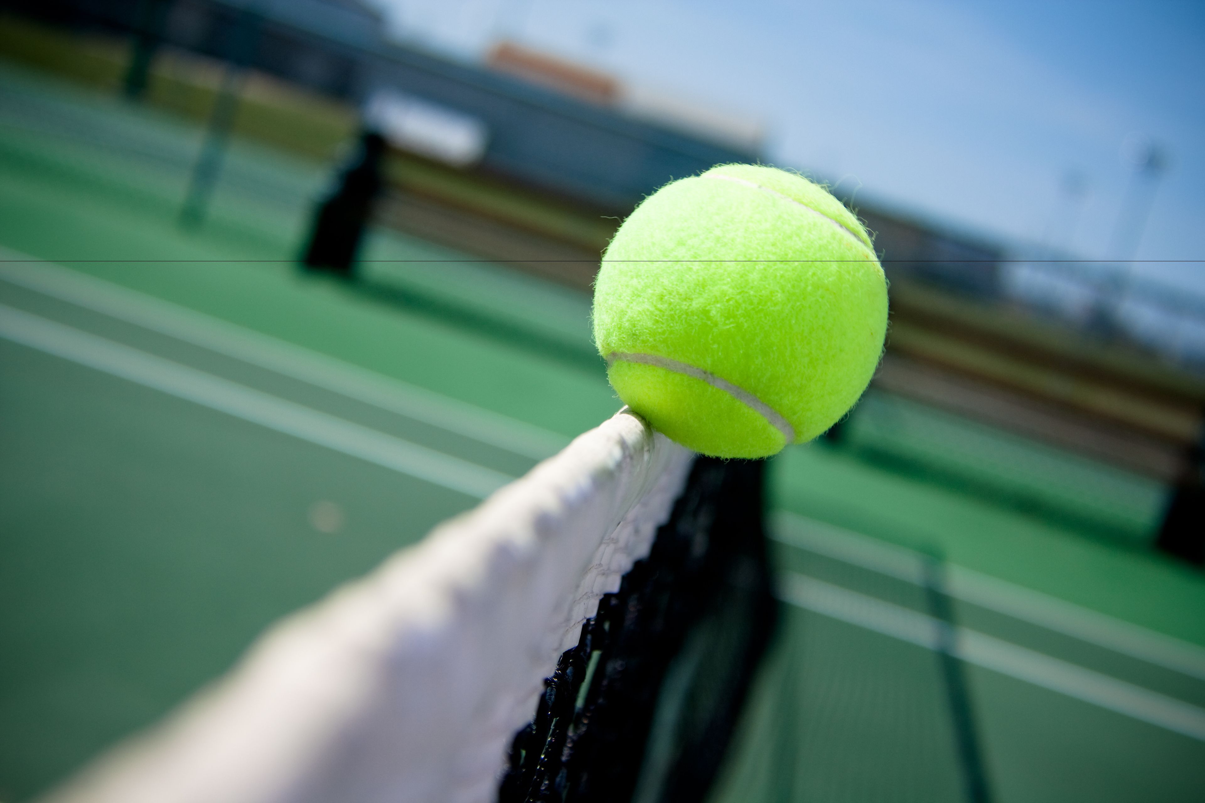 Ein Tennisball auf einem Netz.