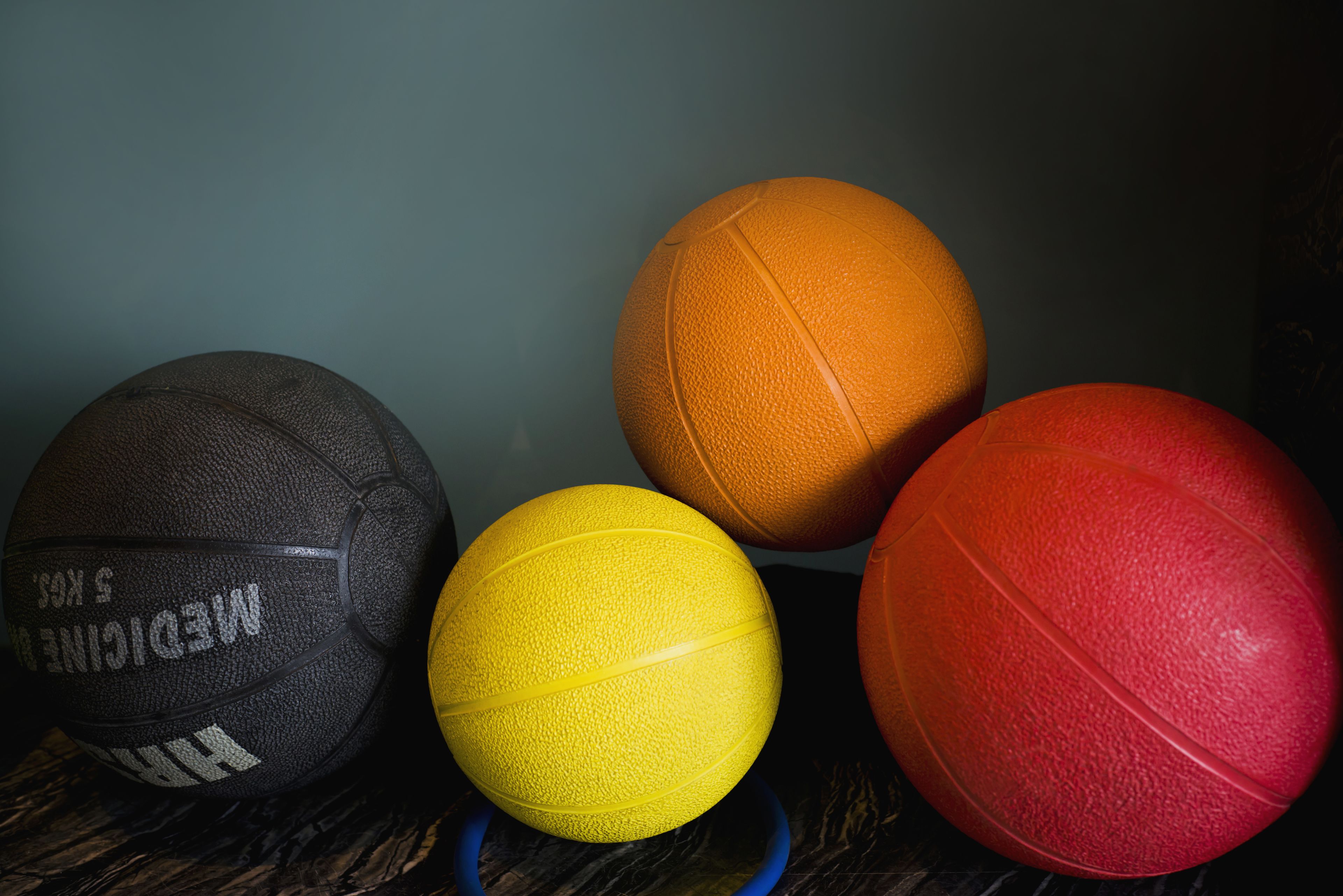 Four basketballs of different colors.