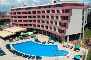 A hotel with a large pool, multiple floors, and outdoor seating areas. - Mena Palace (Sunny Beach)