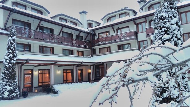 Ett hotell med flera våningar, balkonger och en överbyggd entré.