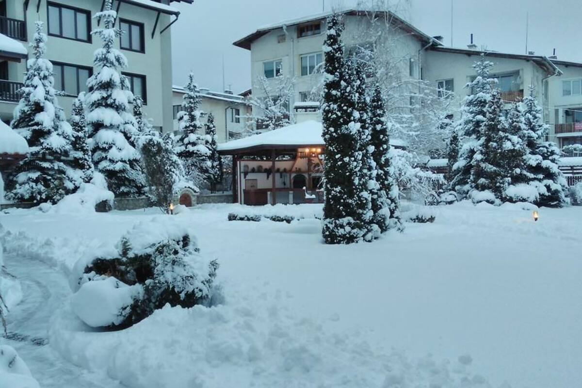 Um pátio coberto de neve, com edifícios ao fundo.