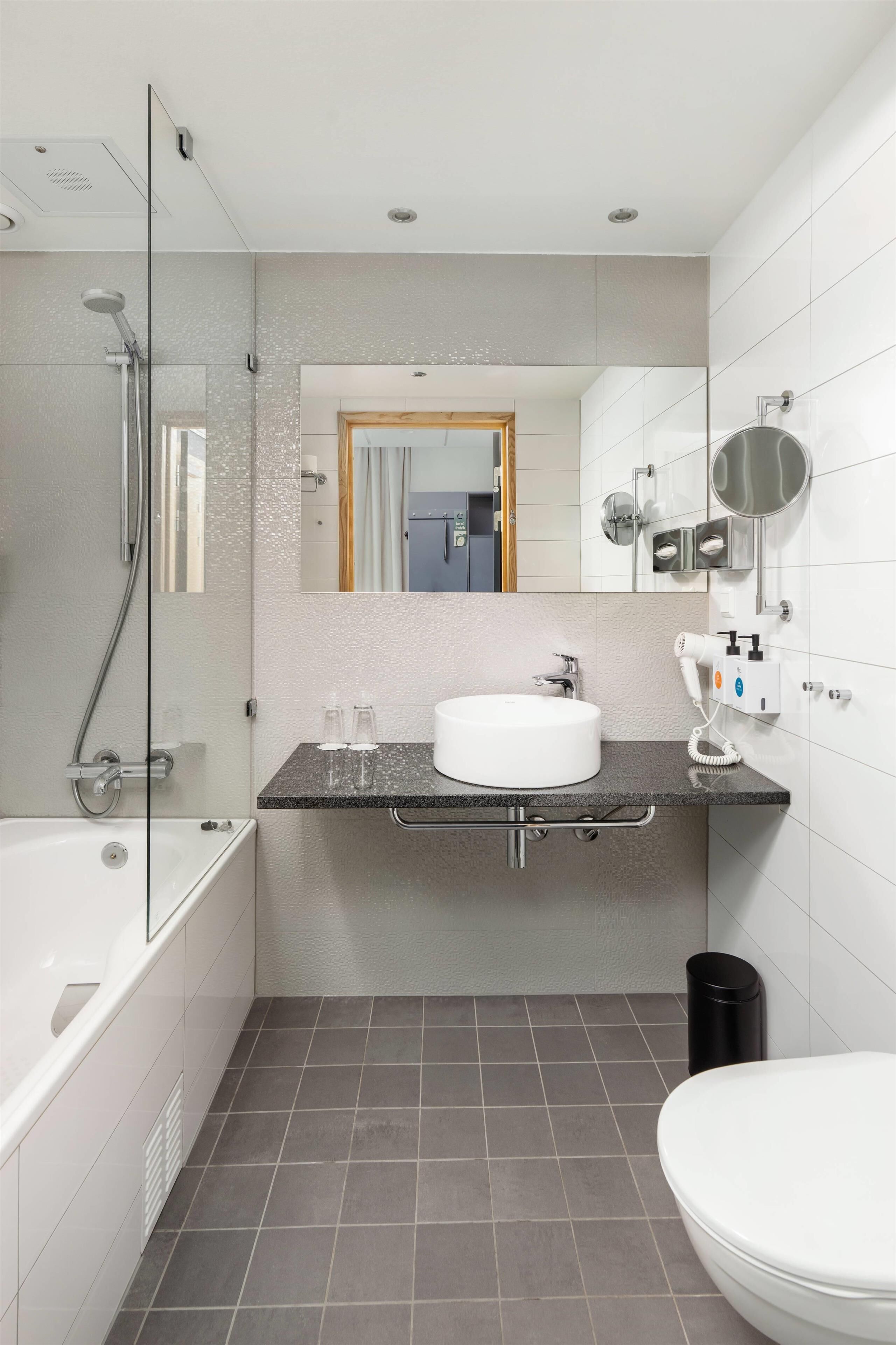 Ein modernes Badezimmer mit einer Badewanne, einem Waschbecken und einer Toilette.