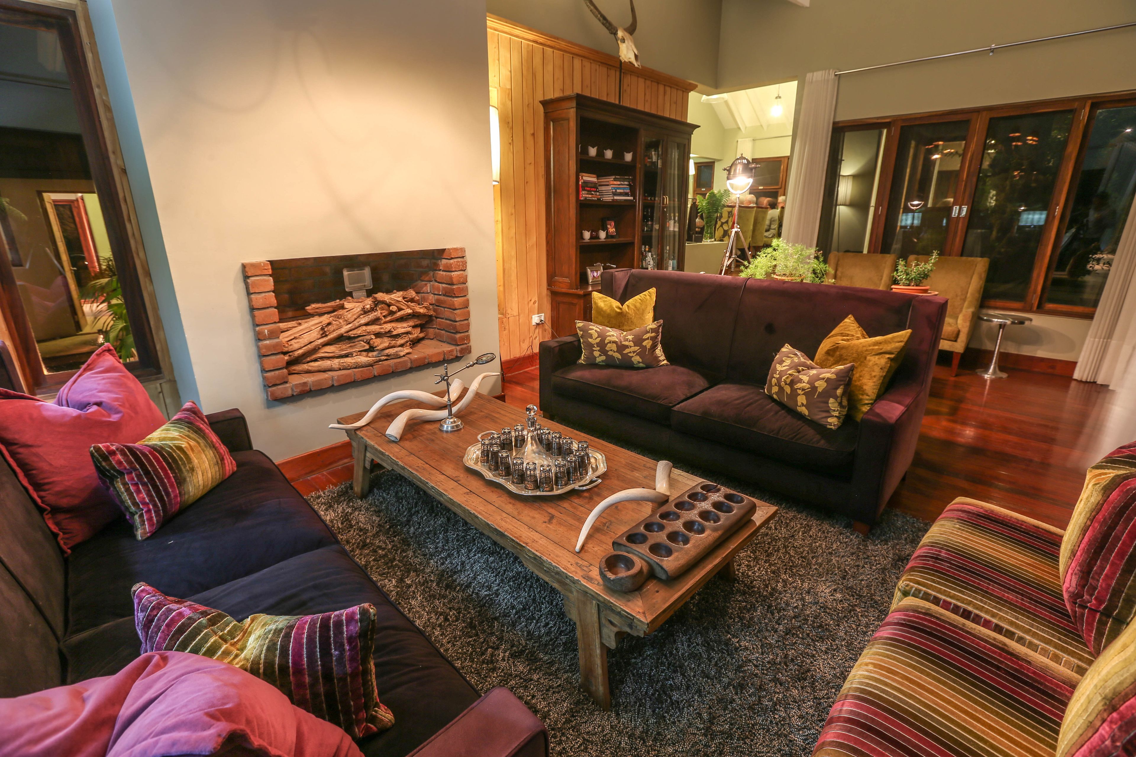 A living room with a fireplace, a wooden cabinet, and a sofa set.
