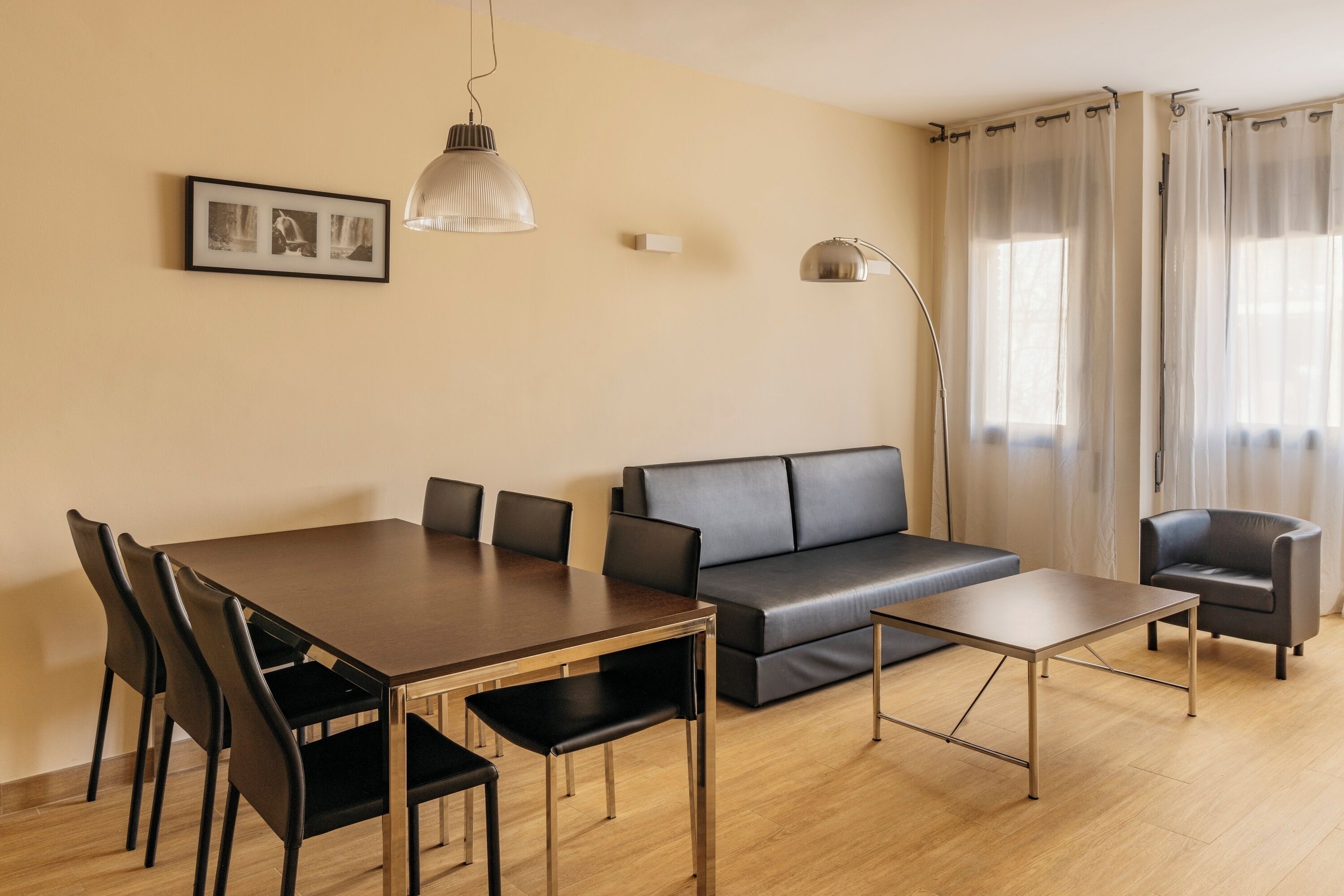 Una sala de estar moderna con una mesa de comedor, sofá y sillas.