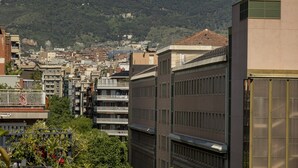 A cityscape with modern buildings, a prominent tower, and a hill with a historical structure in the background. - Villarroel Apartments Barcelona (Barcelona)