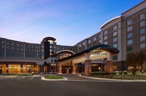 A hotel with a modern design, featuring a curved entrance and multiple floors.