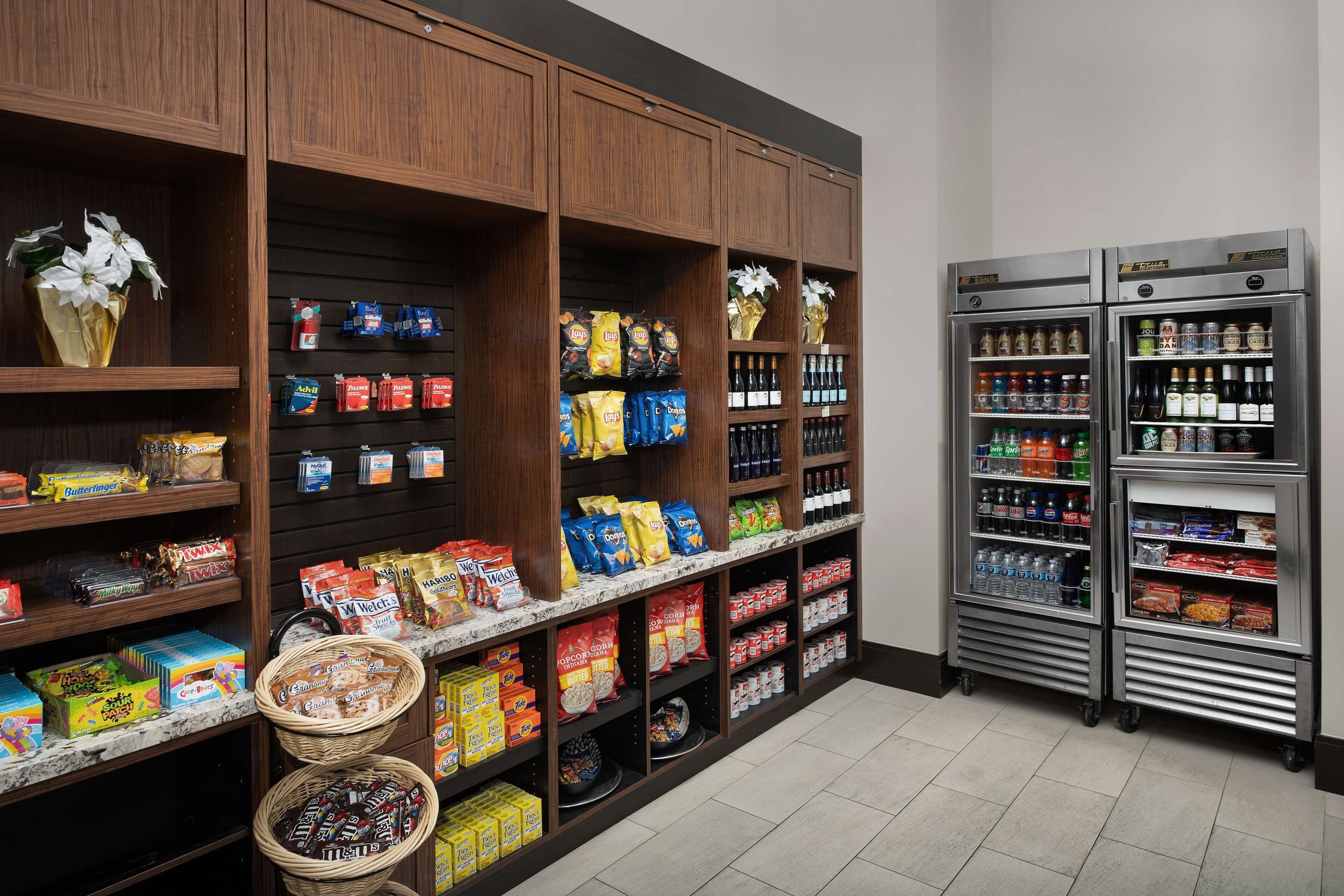 Un supermercado con estantes llenos de aperitivos, bebidas y productos envasados.