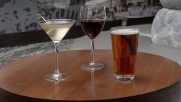 Three glasses of beverages on a round wooden table.