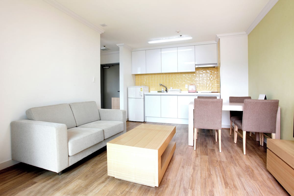Una sala de estar moderna con un sofá, una mesa de centro y un comedor con sillas y una mesa.