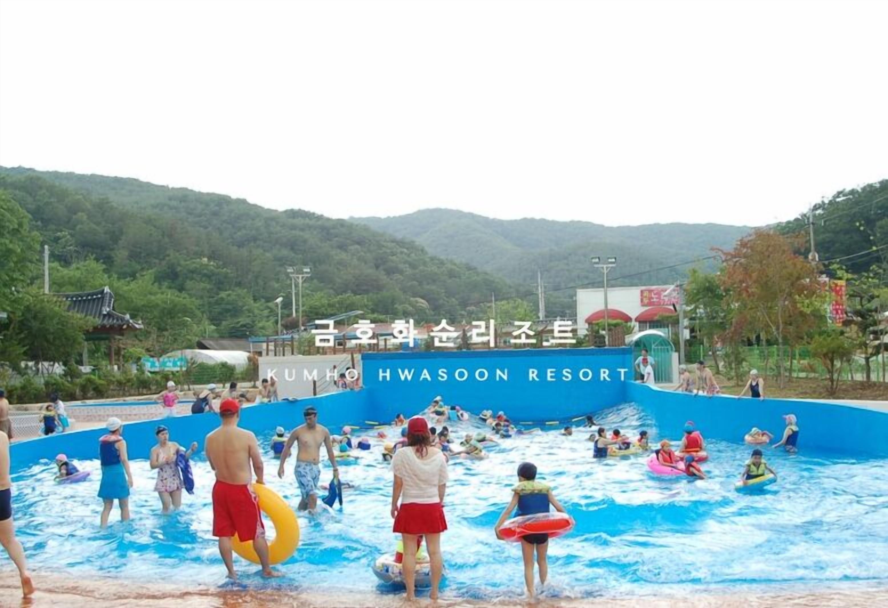 A swimming pool area at KUMHO Hwason Resort with people enjoying water activities.