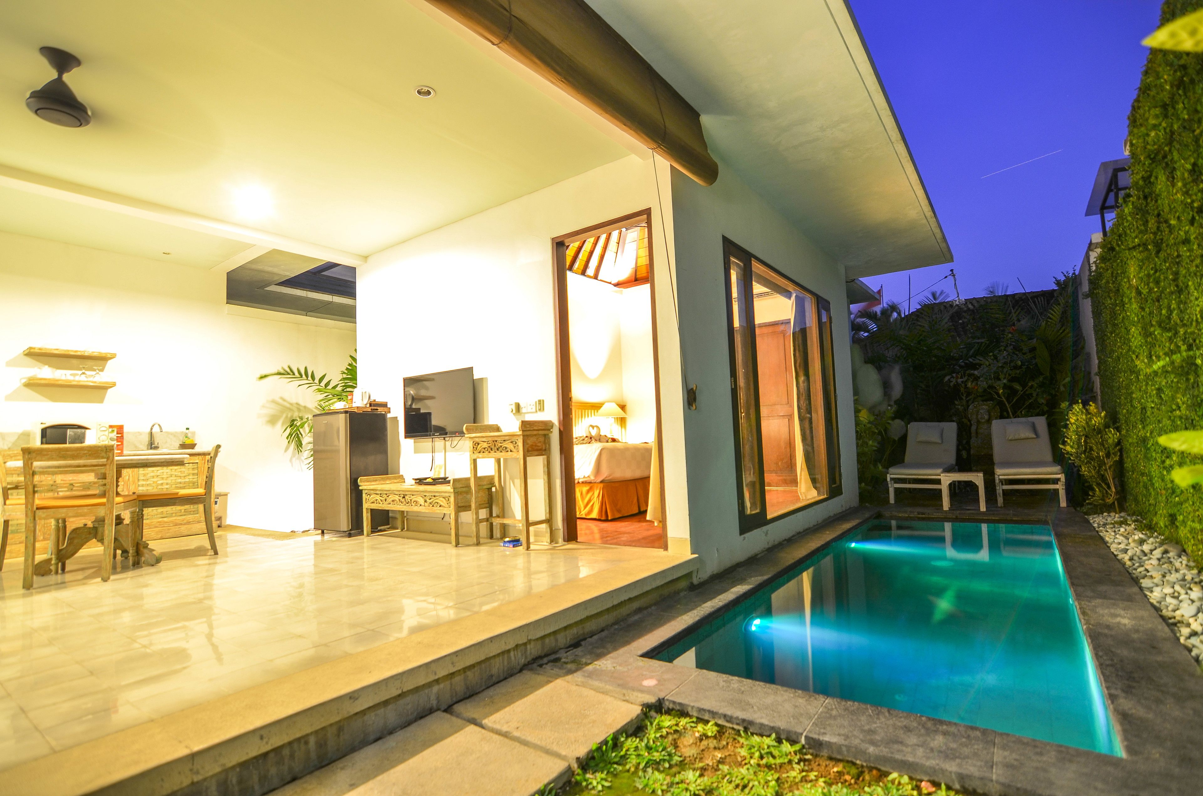 Una casa moderna con piscina, zona pranzo e camera da letto con porta scorrevole.