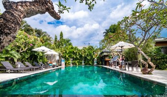 Una piscina al aire libre, sillones reclinables de piscina