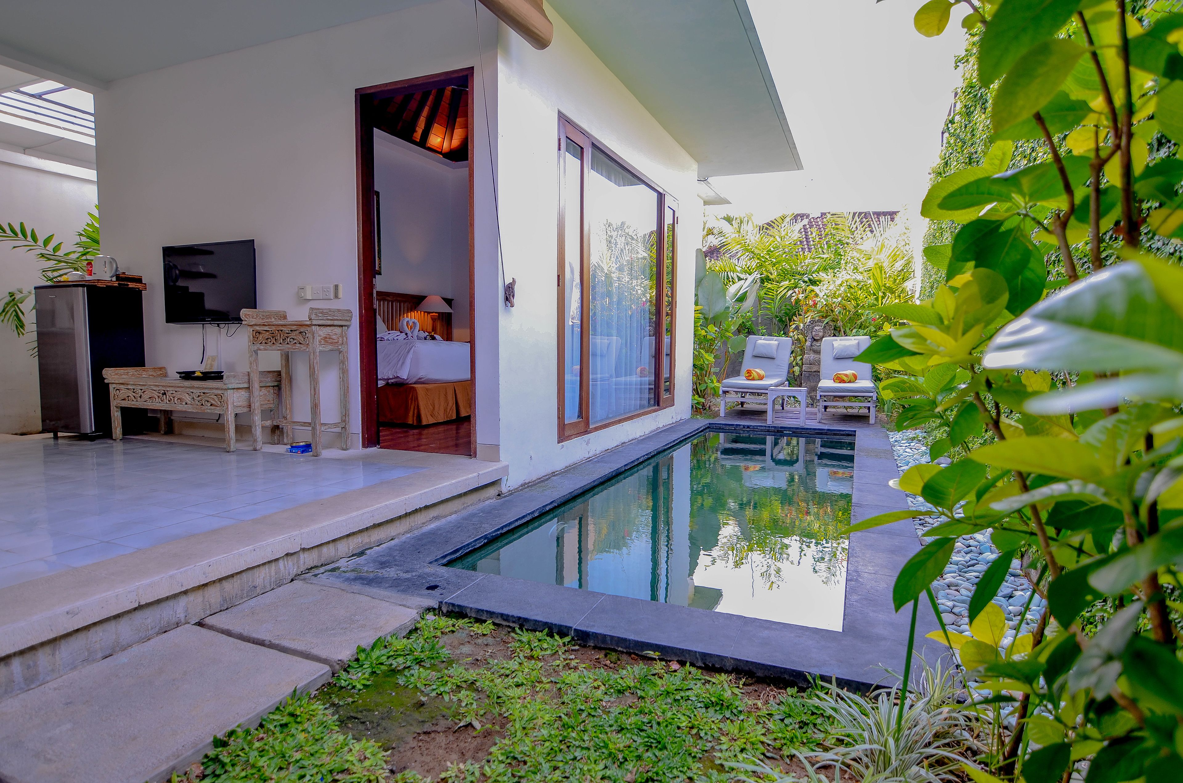 A modern villa with a swimming pool, a bedroom with a large window, and a dining area with a TV.