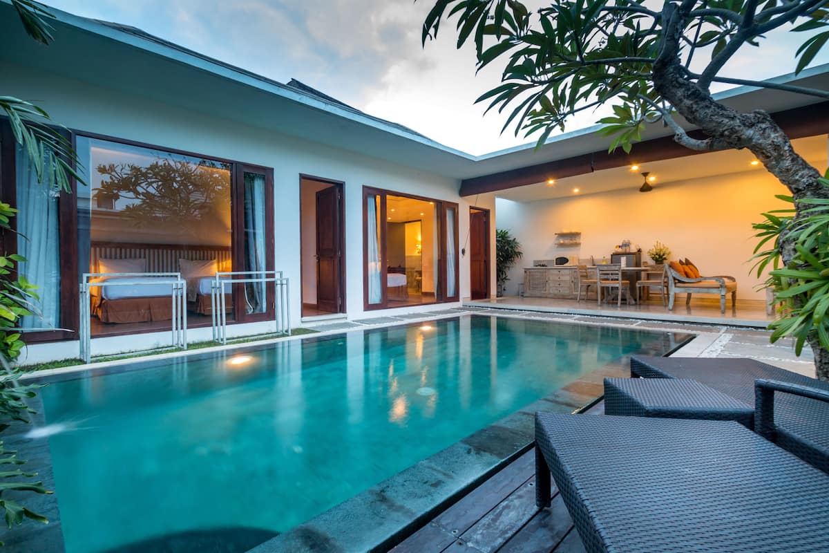 A modern house with a swimming pool, outdoor furniture, and a dining area.