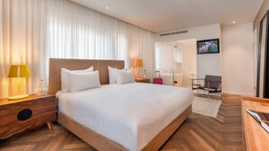 A modern hotel room with a large bed, wooden headboard, and a nightstand with a lamp. - Jacob Shenkin Hotel (Tel Aviv)