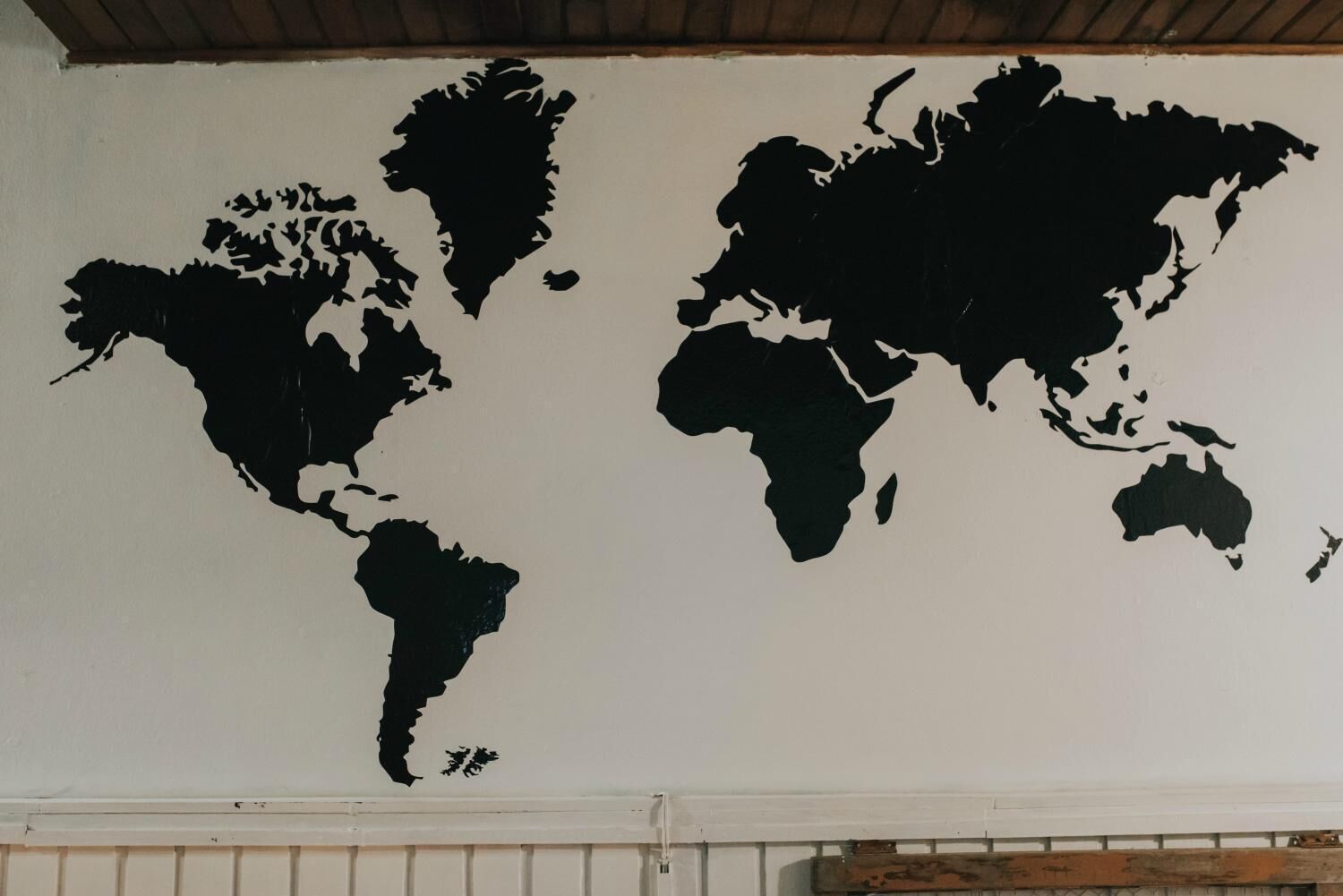 A world map on a white wall.