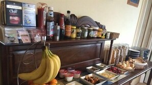 Un bufé de desayuno con diversas frutas, pasteles y bebidas.