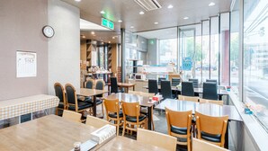 A restaurant with multiple tables and chairs, a clock on the wall, and a menu board. - Tabist Annex Hotel Tetora Hakodate Goryokaku (Hakodate)