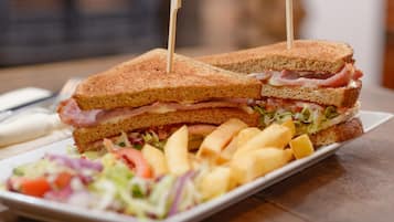 Een boterham met satéprikkers, vergezeld van friet en een salade.