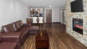A modern living room with a sectional sofa, a coffee table, and a fireplace.