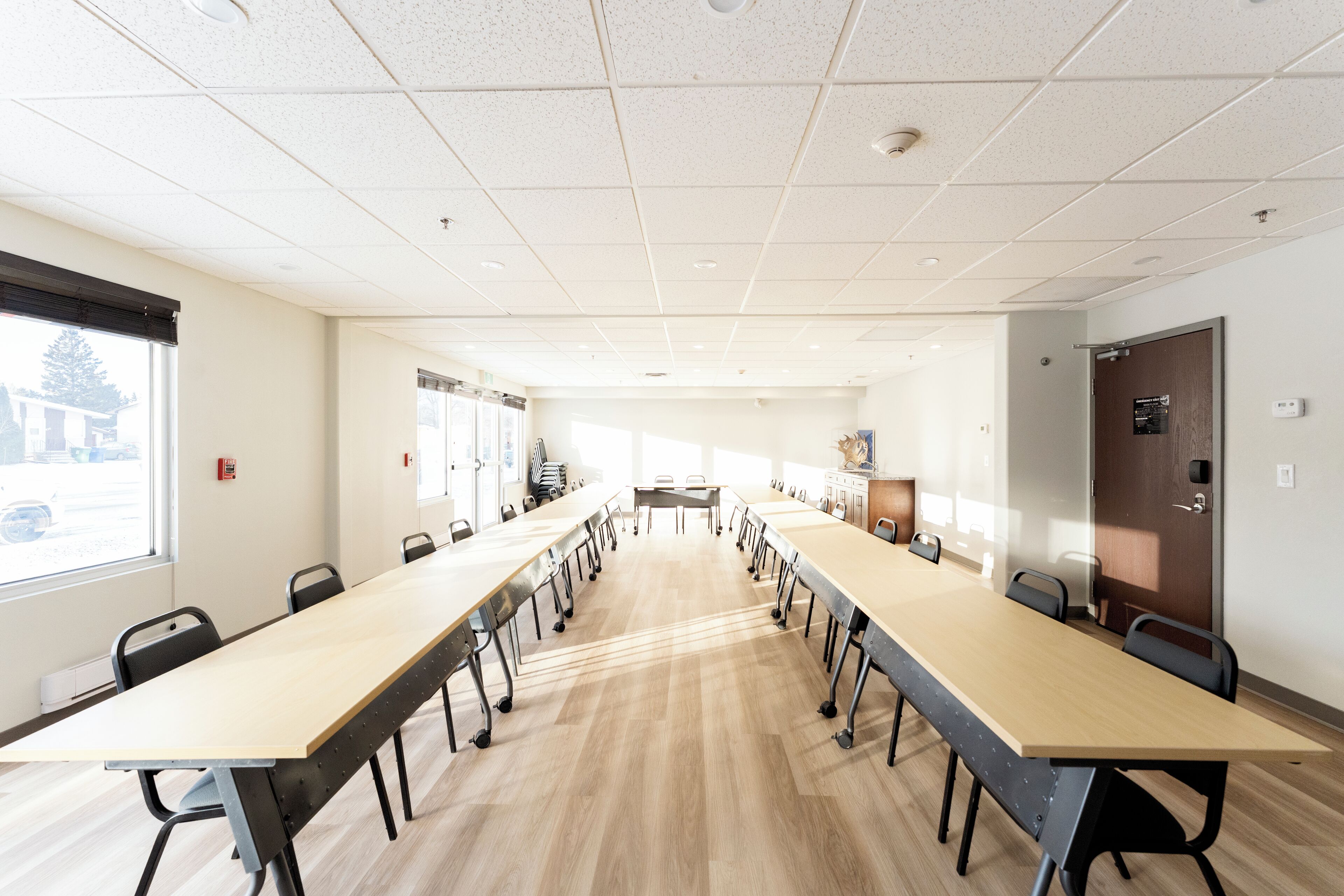 A conference room with a long table, chairs, and a door.