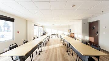 A conference room with a long table, chairs, and a door.