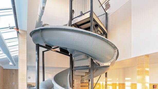 A multi-level indoor water slide with a pool at the bottom.