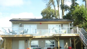 A two-story building with a balcony, outdoor seating, and a grill area. - Bayside Inn & Waterfront Suites (Kingston)