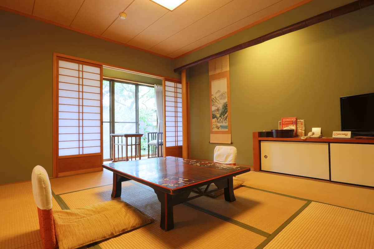 A traditional Japanese room with tatami flooring, a low table, and sliding doors.