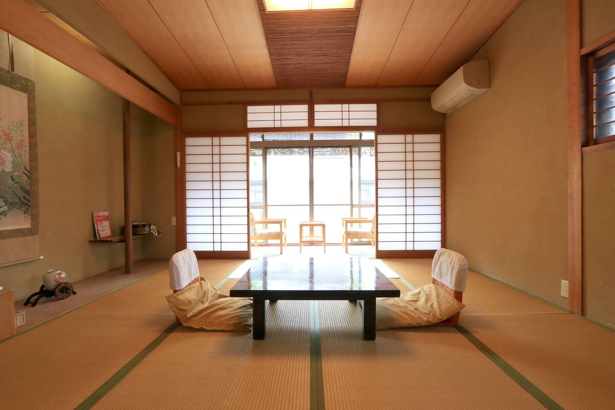 A tatami room with a low table and chairs, a shoji screen, and a traditional Japanese-style room.