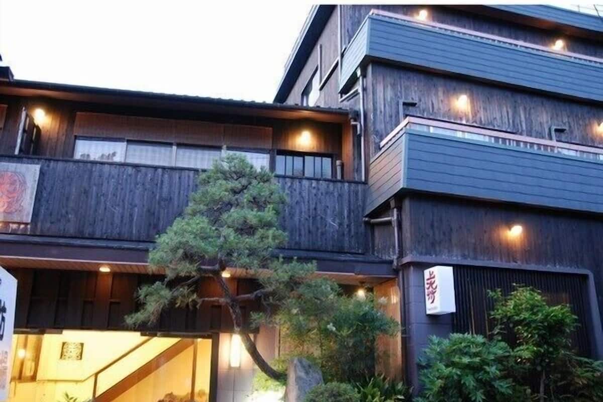 A multi-story building with a wooden facade, a visible entrance, and a sign with Japanese characters.